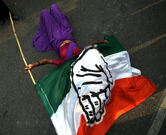 A supporter lies on the ground holding a Congress party flag