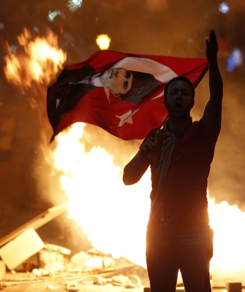 An anti-government protester holds a Turkish national flag with a portrait of Mustafa Kemal Ataturk, founder of modern Turkey, on it during a demonstration in Ankara