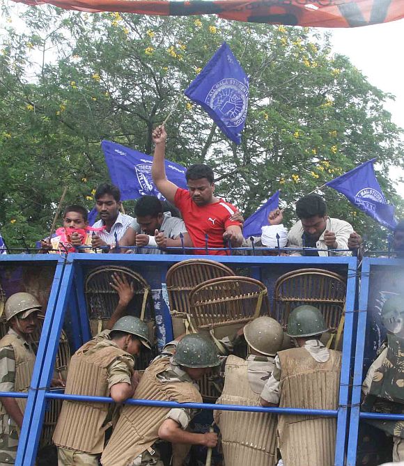 Police personnel trying to stop Telangana activists from crossing a barricade