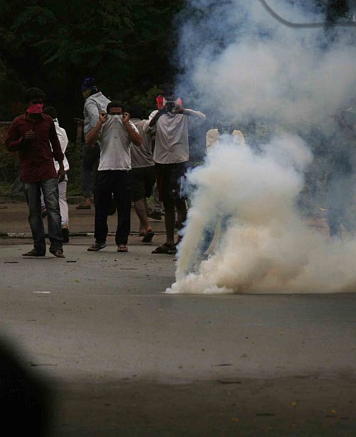 Telangana protestors take cover from teargas shells