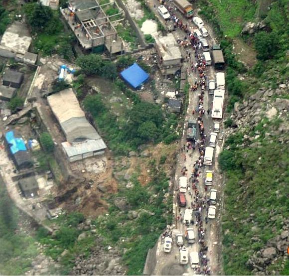 This image shows people abandoning their vehicles on a road that was destroyed in a landslide