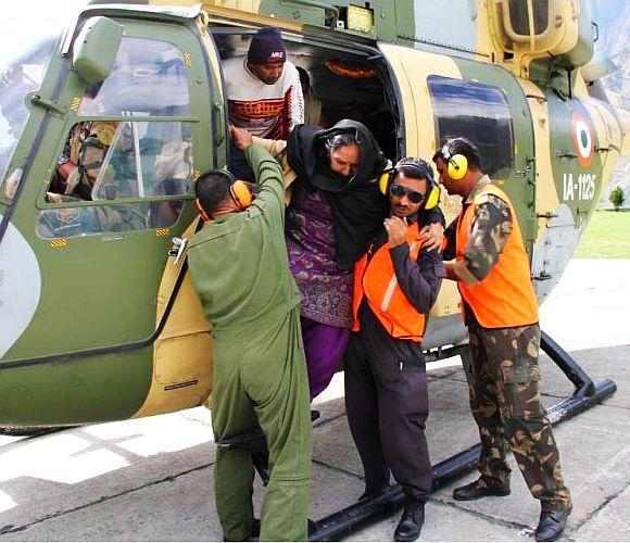 An army helicopter rescues stranded people in rain ravaged Uttarakhand on Thursday