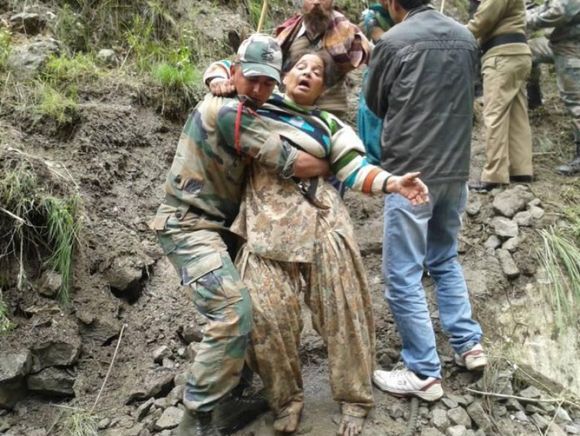 An army personnel rescues an injured person in rain-ravaged Uttarakhand