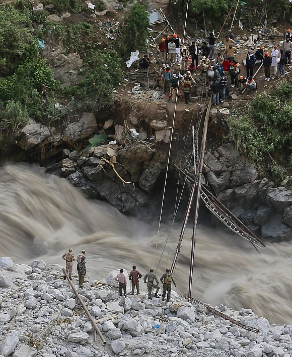 Soldiers try to repair a temporary footbridge over River Alaknanda after it was destroyed, during rescue operations in Govindghat in the Himalayan state of Uttarakhand