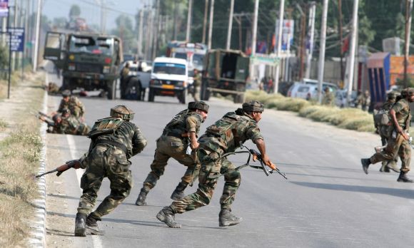 Army personnel running for cover after a militant strike on a convoy outside Srinagar on Monday