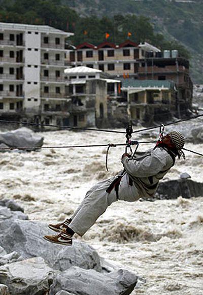 A man is pulled across to safety on a rope during a rescue operation in Govindghat on Sunday