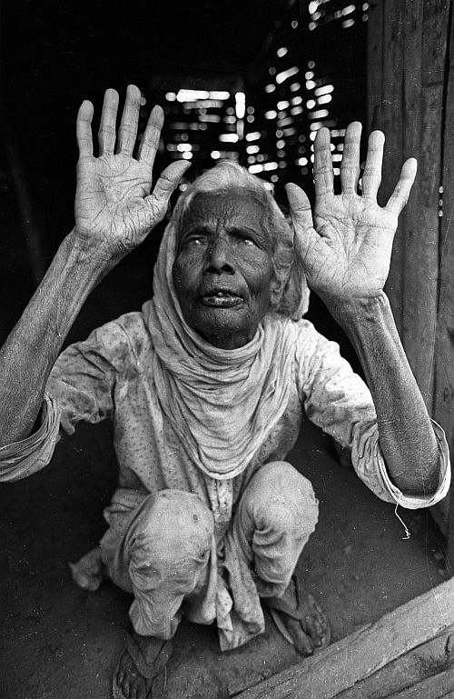 An aged blind horror-struck woman lifts her hands on October 12, 1987, near Bhopal, as she recalls the death-night of the Bhopal gas disaster which took place on December 3, 1984