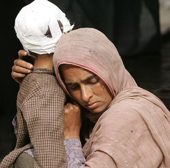 A Kashmiri woman holds her injured child outside a hospital in Karnah near the LOC