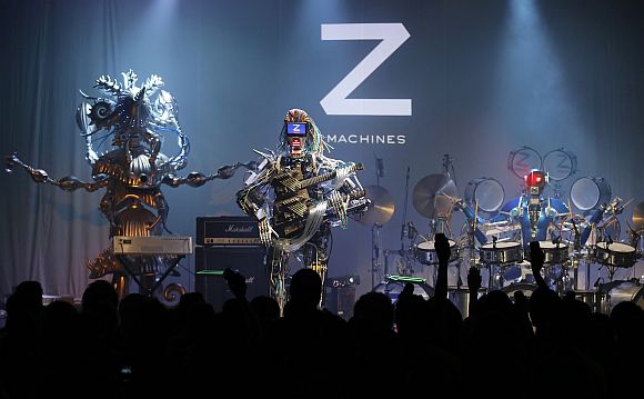 Members of the robot rock band Z-Machines, guitarist Mach (C), keyboardist Cosmo (L) and drummer Ashura perform during the band's debut live concert
