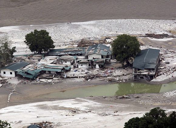 A view shows the damaged houses next to a river after heavy rains in the Himalayan state of Uttarakhand