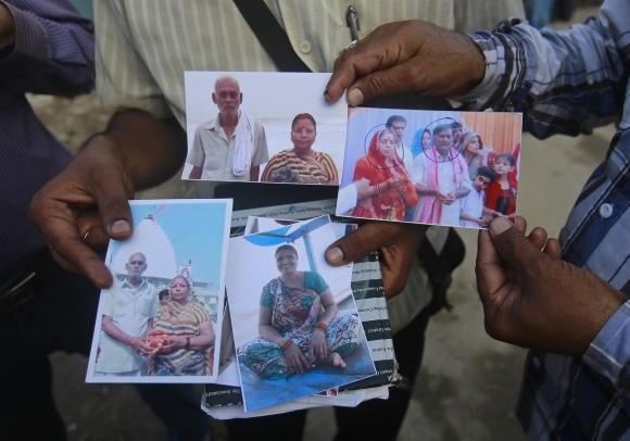 Relatives of missing people, affected by the flash floods and landslides, display their photographs outside the Indian Air Force base in Dehradun