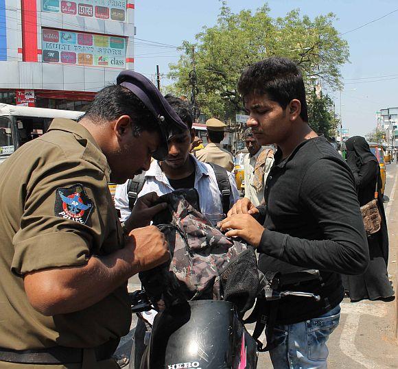 A policeman checks the bag of a biker in Hyderabad