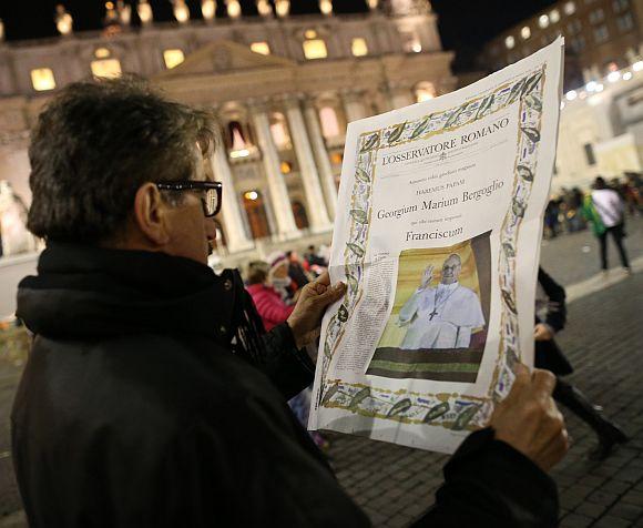 A man reads a special edition of L'Osservatore Romano newspaper which carries a photograph of newly elected Pope Francis I on March 13, 2013 in Vatican City