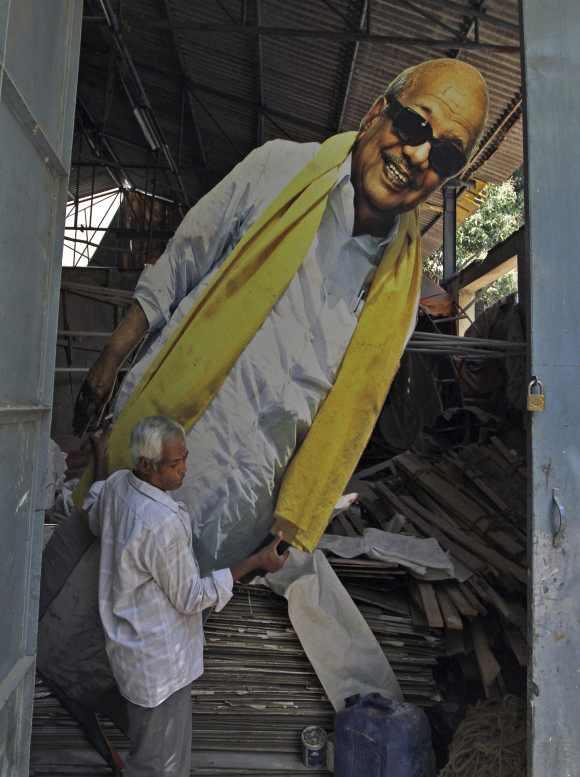 A man carries a poster of DMK chief M Karunanidhi