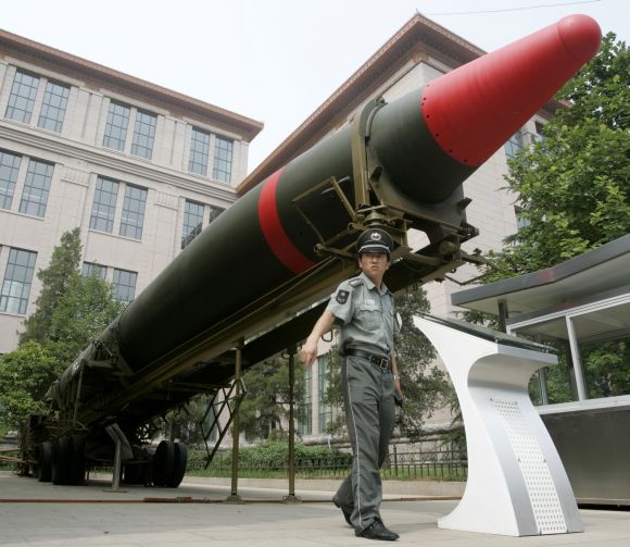 A security guard stands under the Chinese DF-2 ground-to-ground nuclear bomb at an exhibition in Beijing.