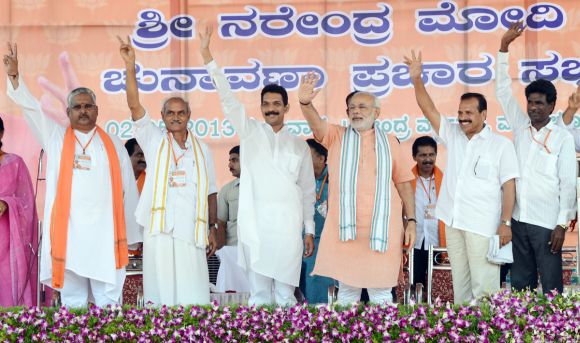 Narendra Modi gestures with BJP leaders in Karnataka during the Mangalore rally