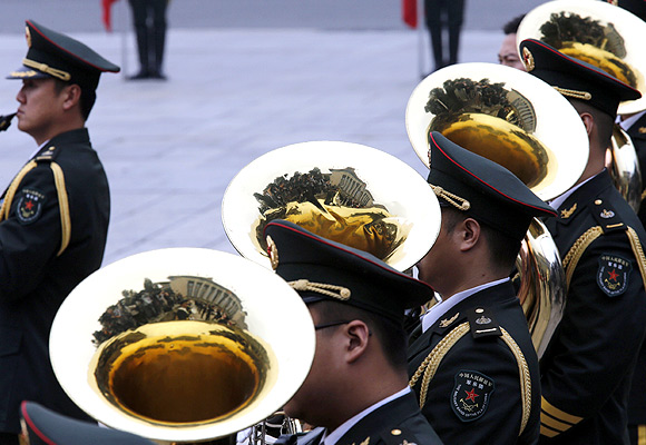 Members of a band play their instruments during an official welcoming ceremony in Beijing