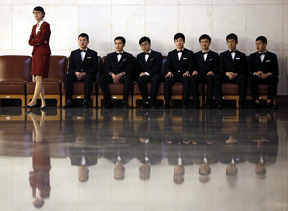 Staff members of the Communist Party of China wait at the Great Hall of the People in Beijing