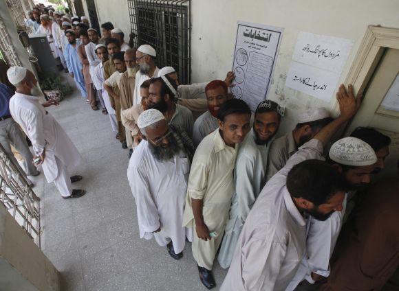 Voters line up as they wait for their turn to cast their vote at a polling station in Karachi on Saturday.