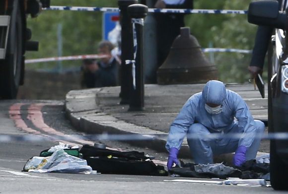 A police forensics officer investigates a crime scene where one man was killed in Woolwich on Wednesday