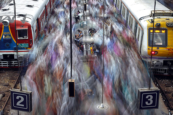 Commuters disembark from crowded suburban trains during the morning rush hour