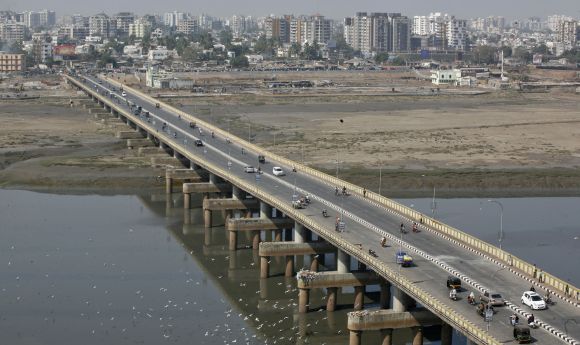 Vehicles move over a bridge built over the river Tapi in Surat