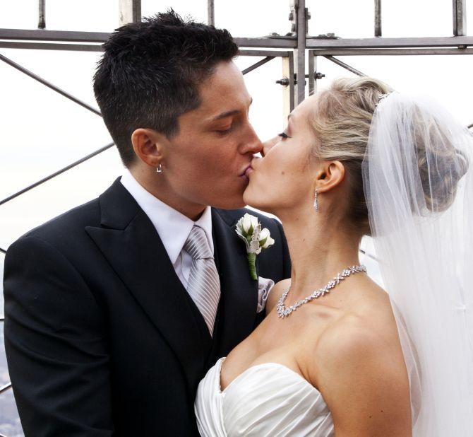 A couple kisses during their wedding ceremony at New York's Empire State Building