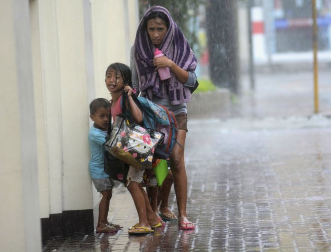 A mother takes refuge with her children as Typhoon Haiyan hits Cebu city on Friday