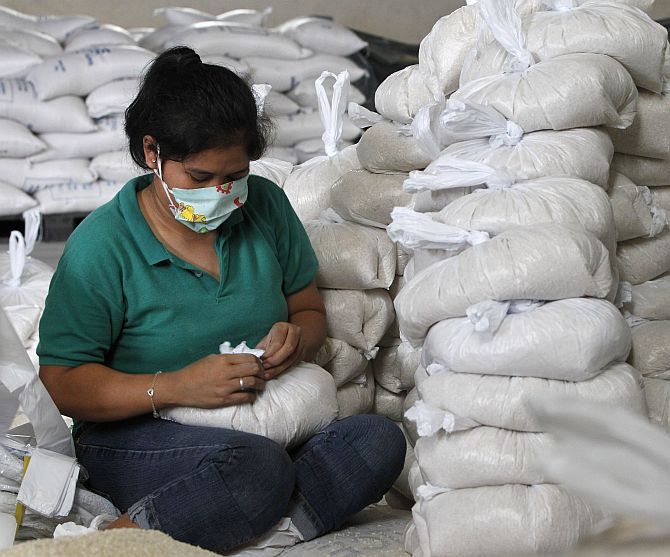 A volunteer packs rice inside a Department of Social Welfare and Development warehouse before shipping them out to the devastated provinces hit by Typhoon Haiyan, in Manila on Friday