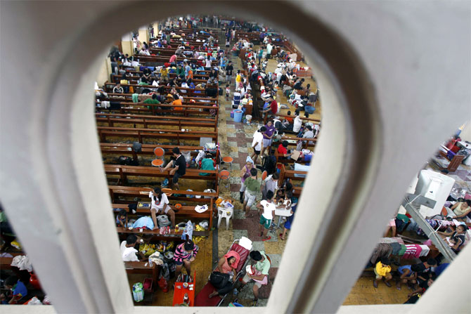 Survivors seek refuge inside a church which has been converted into an evacuation center after super Typhoon Haiyan battered Tacloban city