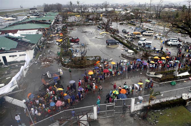 Typhoon victims queue for food and water outside the airport