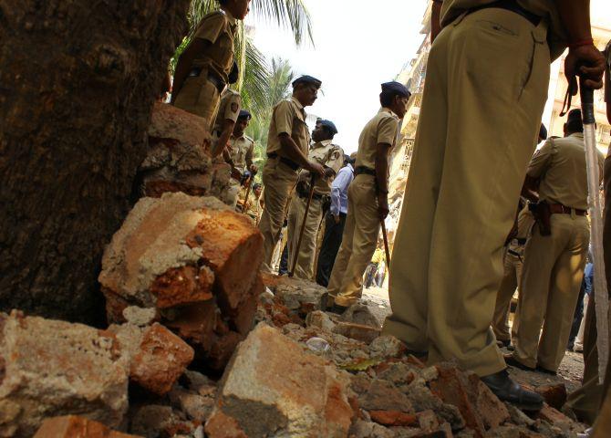 Policemen stand guard outside Campa Cola Compound after BMC workers broke open the main gate