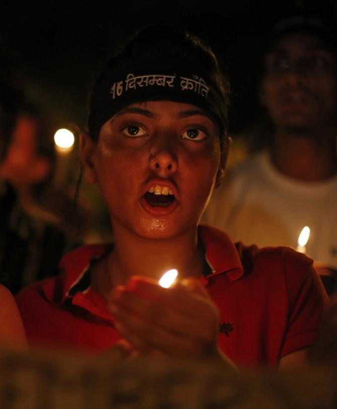 Demonstrators shout slogans as they hold candles during a candle light vigil for the Delhi gang rape victim