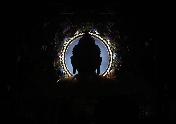 An idol of Buddha is silhouetted at the Tibetan Monastery in Lumbini, south-west of Kathmandu