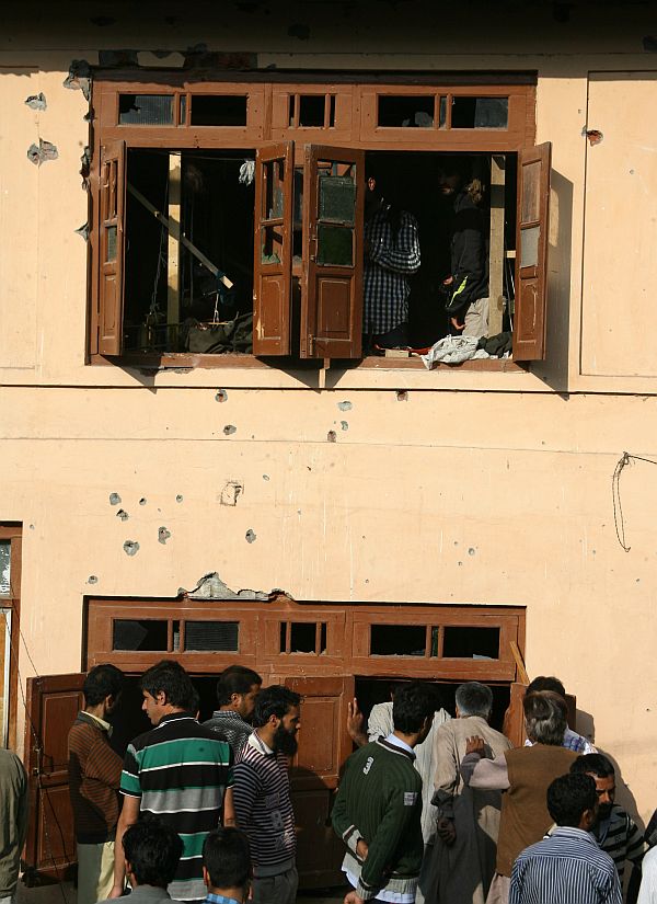 Local residents inspect the house where the militant was reportedly hiding