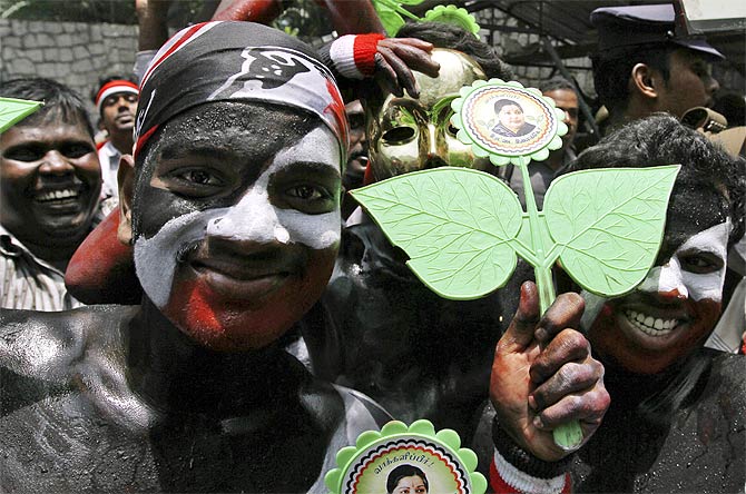 Supporters of AIADMK display the party's election symbol