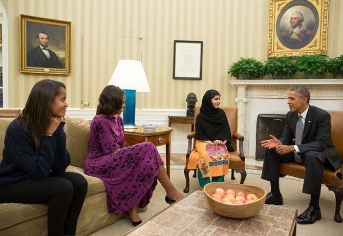 President Barack Obama, First Lady Michelle Obama, and their daughter Malia meet with Malala Yousafzai, the young Pakistani schoolgirl who was shot in the head by the Taliban a year ago, in the Oval Office