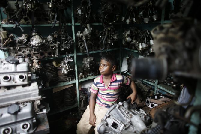 Sujon, 7, sits inside a vehicle spare parts store, as he works in Dholaikhal, Dhaka