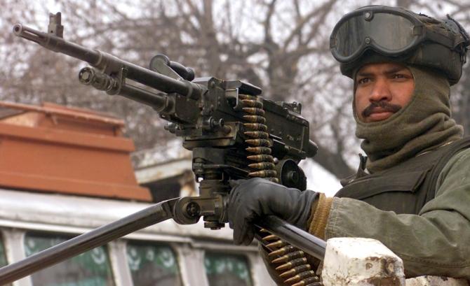 An Indian paramilitary trooper stands guard outside an army camp in Veerinag, 90 km south of Srinagar