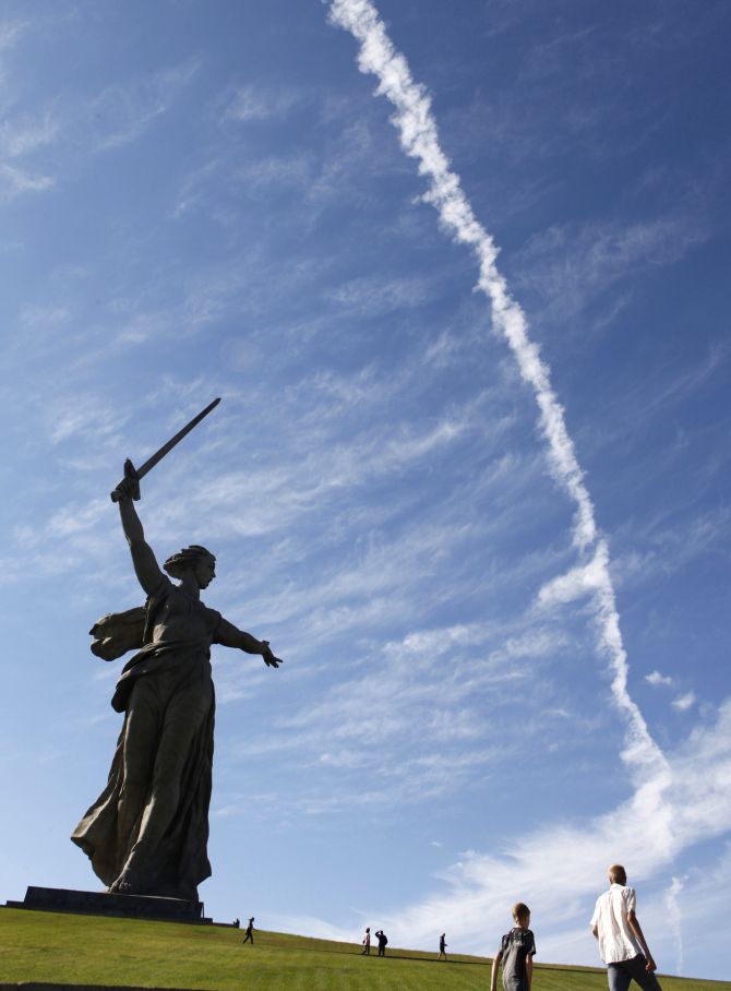 People walk by 'The Motherland Calls' monument in Russia's southern city of Volgograd