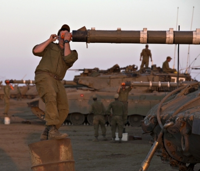An Israeli soldier adjusts sights on a tank during a drill in the Israeli-occupied Golan Heights amid the Syria crisis 