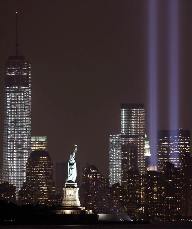 The Tribute in Light is illuminated next to the Statue of Liberty and One World Trade Centre during events marking the 12th anniversary of the 9/11 attacks on the World Trade Centre in New York