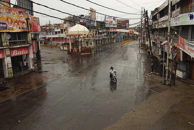  A man rides his motorbike on a deserted street during curfew in Muzaffarnagar. Political parties have exploited the situation to secure their vote