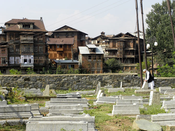 A Kashmiri prays at a grave in Zainkadal, Srinagar 