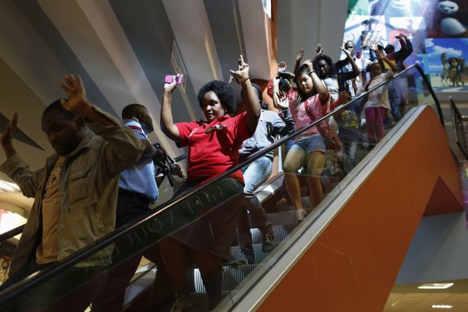 Civilians escape an area at the Westgate Shopping Centre in Nairobi 