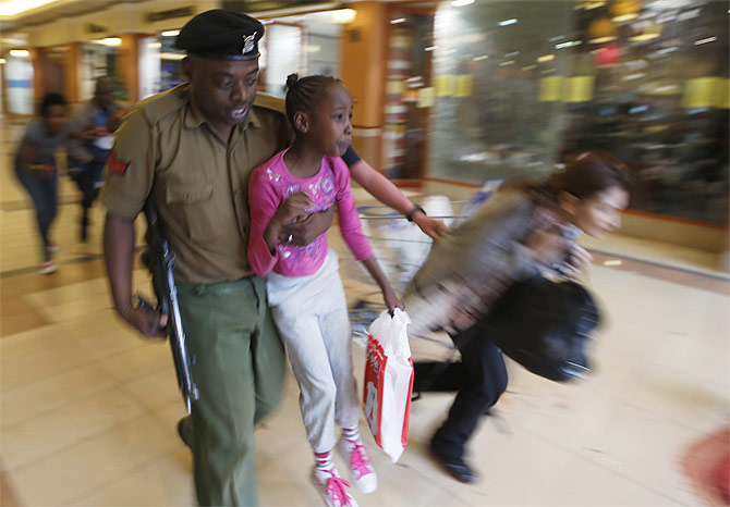 A soldier carries a child to safety as armed police hunt gunmen who went on a shooting spree at Westgate shopping centre in Nairobi