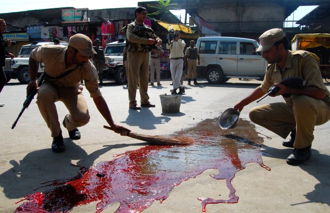 Security personnel wash the blood of the CISF jawans who were attacked in Srinagar