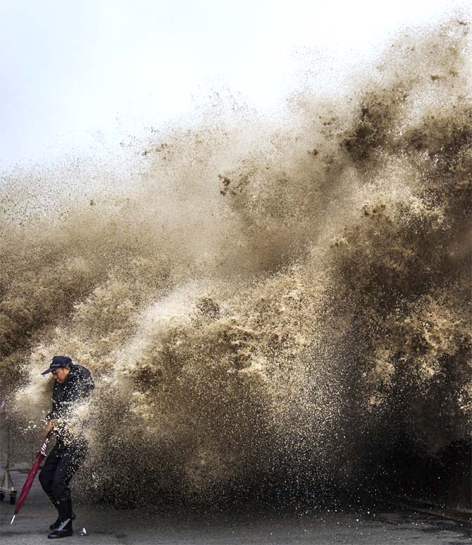 A man dodges tidal waves under the influence of Typhoon Usagi in Hangzhou, Zhejiang province