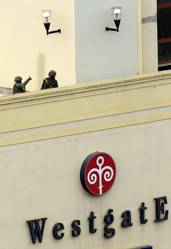 Kenya Defence Forces soldiers give the thumbs up at the roof top of the Westgate shopping mall, on the fourth day since militants stormed into the mall, in Nairobi