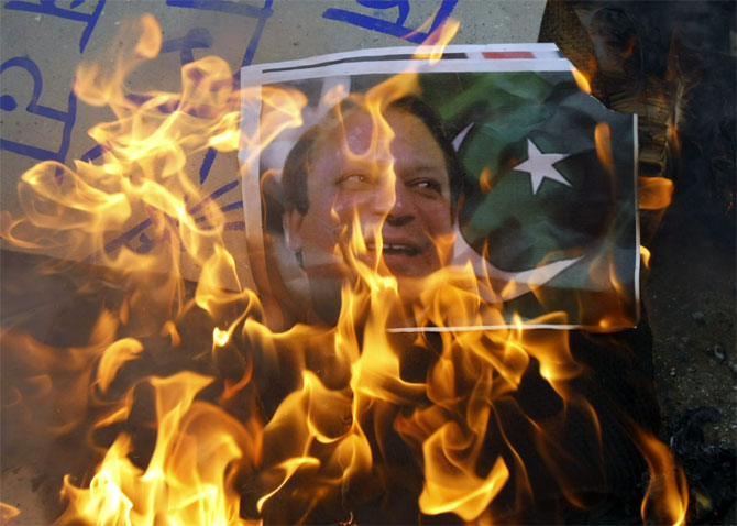 Protesters burn a poster of Pakistan Prime Minister Nawaz Sharif in Ahmedabad.